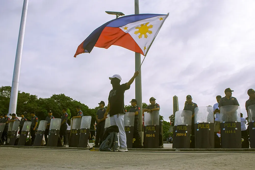 The philippine flag being raised against a cloudy sky - alas pilipinas odds