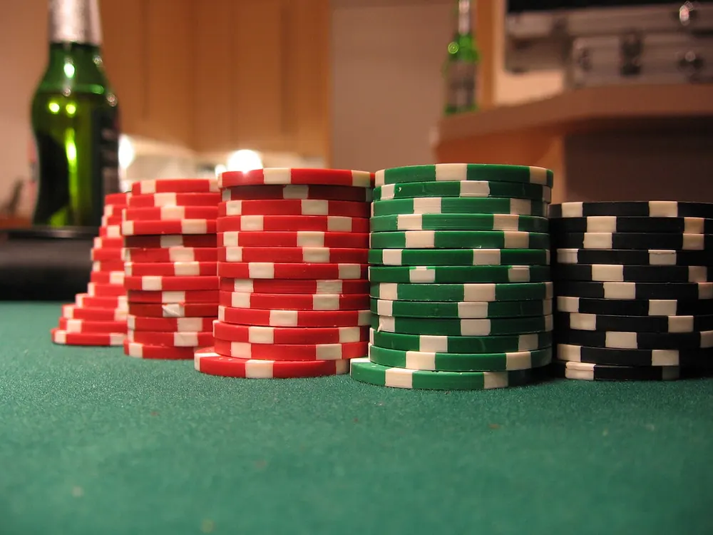baccarat banker vs player odds - Stacks of casino chips on green felt, representing Banker and Player bets in baccarat