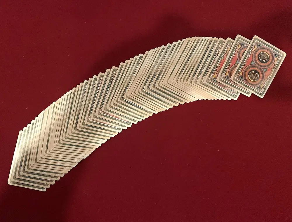 baccarat tie bet payout - Deck of playing cards fanned on red felt, representing the baccarat tie bet
