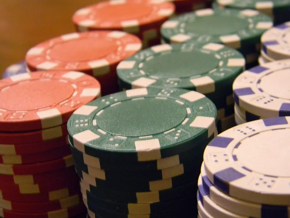 Close-up of casino chip stacks, illustrating the cost of tie bets - baccarat tie bet payout