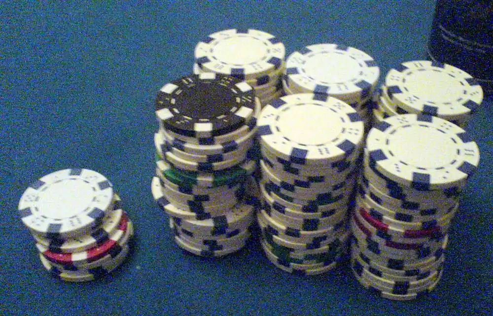 Stacks of casino chips on a blue table - baccarat tips for beginners