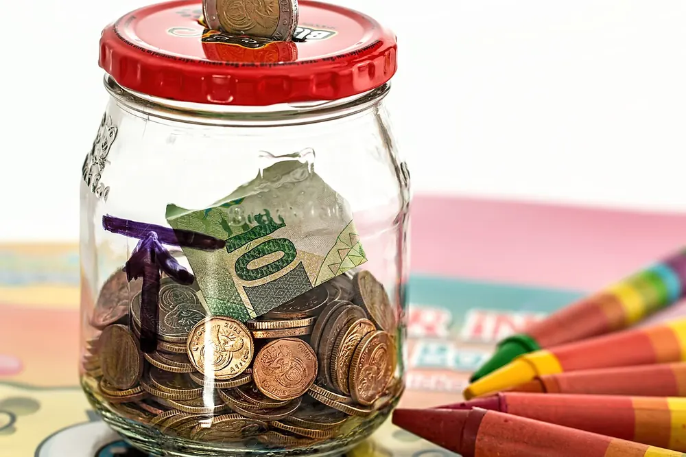 bankroll management betting - Glass jar of coins and notes, representing a separate betting bankroll