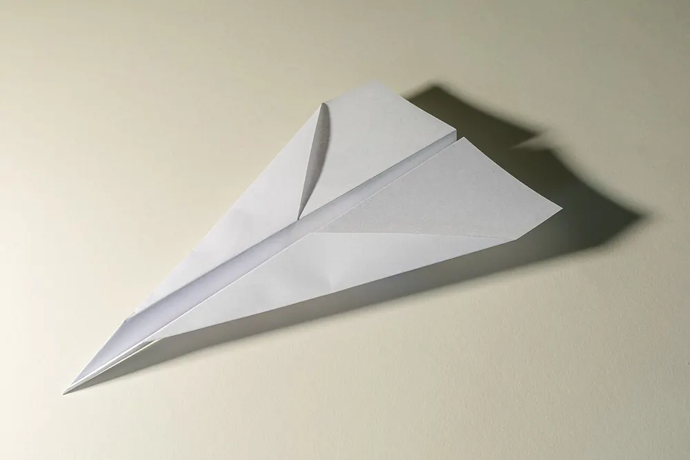 cheapest way to send crypto philippines - Paper airplane on a light background, representing sending crypto cheaply
