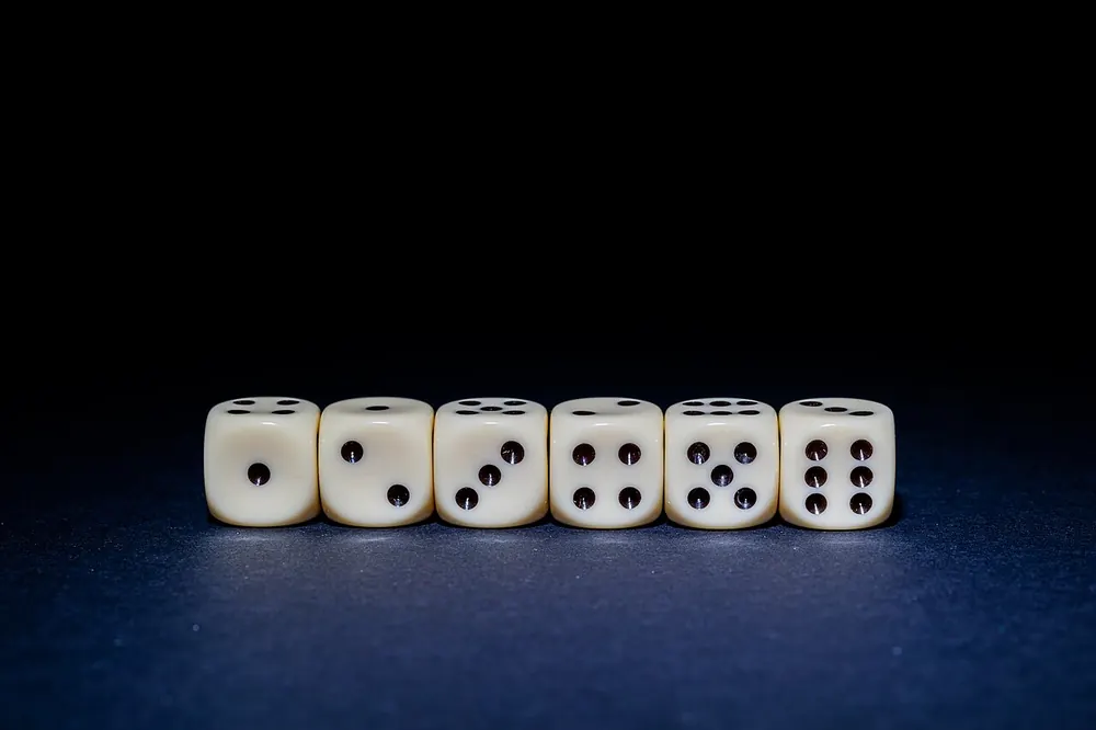color game perya technique - a row of dice lit on a dark table