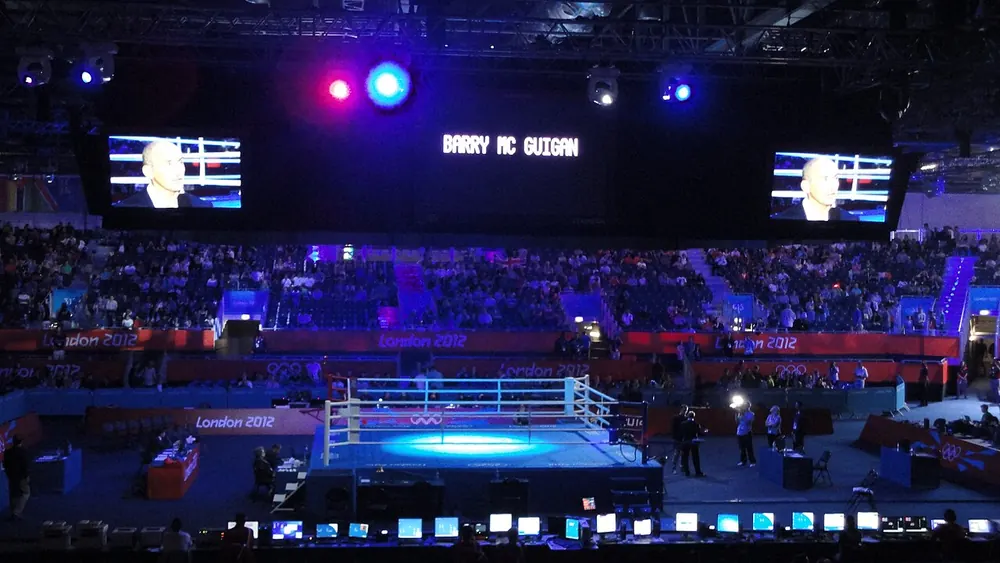 Boxing ring in the middle of a darkened arena with big screens - filipino boxer fight odds