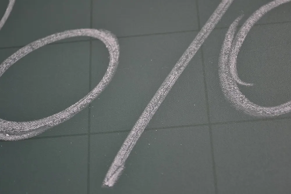 Percentage sign drawn in chalk, illustrating bonus wagering requirement maths - first deposit bonus crypto casino