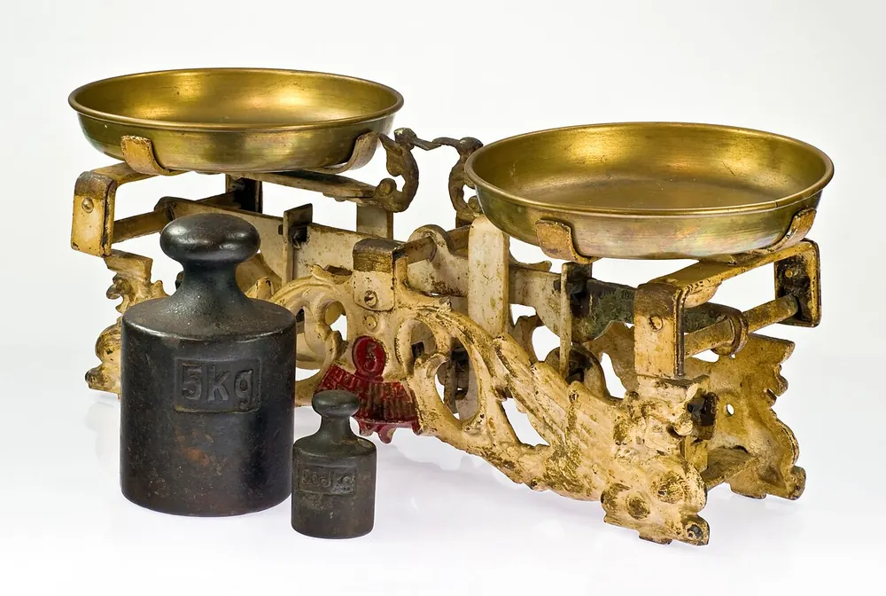 A brass balance scale with weights - free bet vs bonus cash