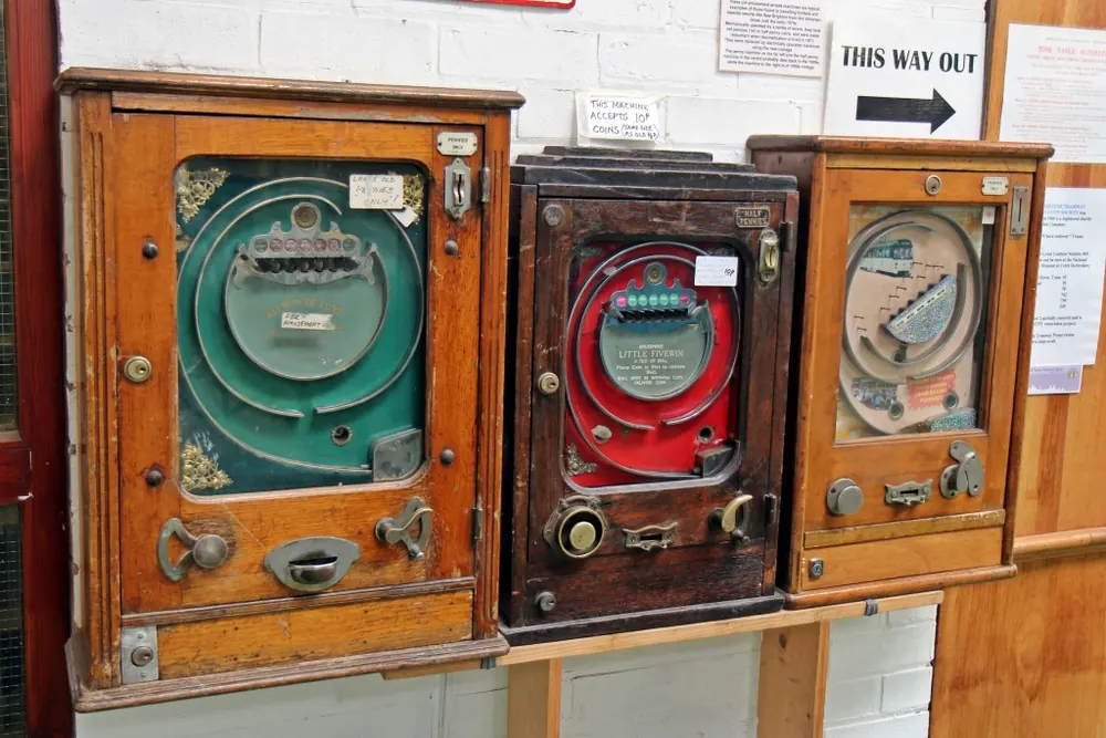 high volatility vs low volatility slots - Row of vintage coin-operated slot machines, representing high and low volatility slots