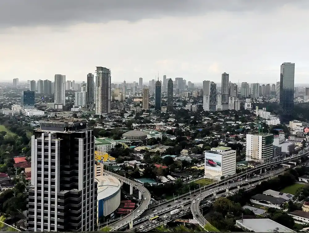 how to buy usdt in okx using gcash - Aerial view of Metro Manila high-rises and expressway