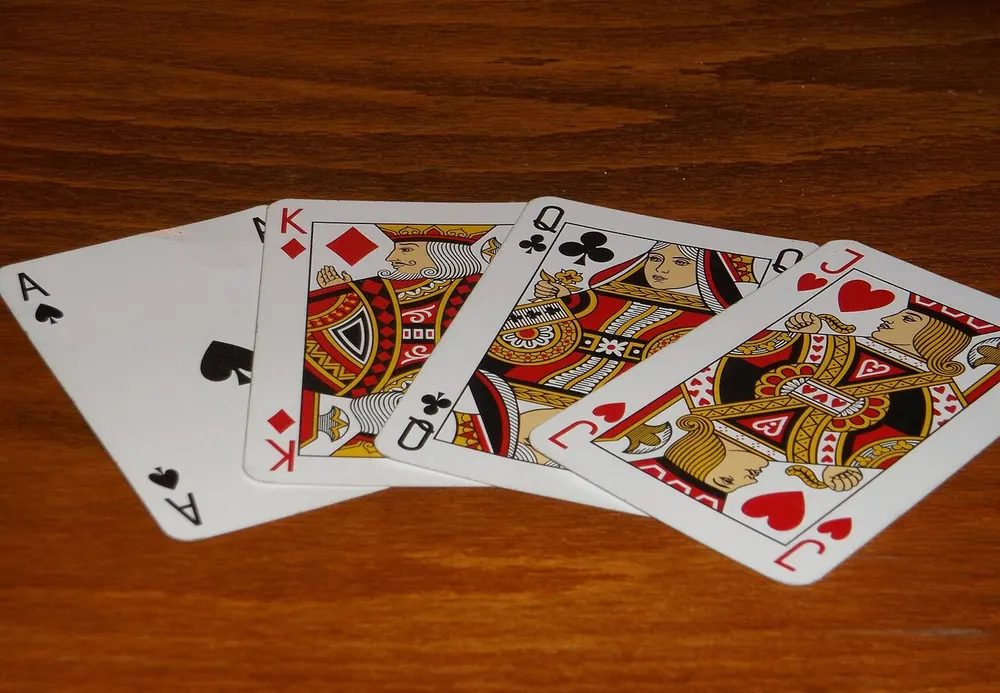 Playing cards spread on a wooden table, comparing lucky 9 and baccarat - lucky 9 vs baccarat