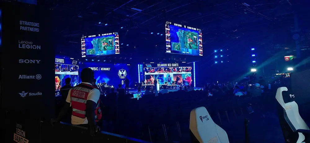 mlbb tournament betting - Darkened esports arena with large screens during an international tournament
