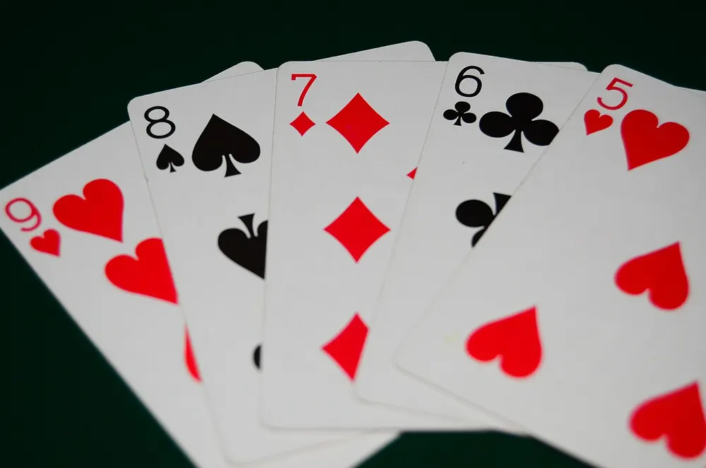 Five-card poker hand on green felt, illustrating poker hand rankings - online poker philippines real money