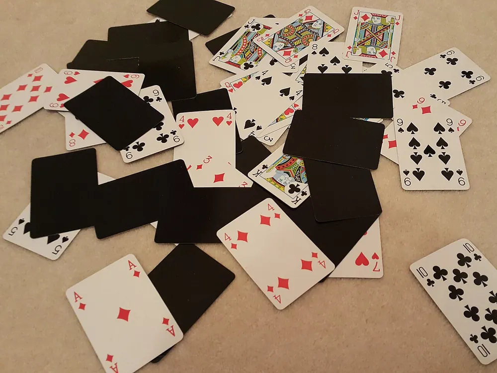 paano maglaro ng baccarat - Playing cards scattered face up and face down