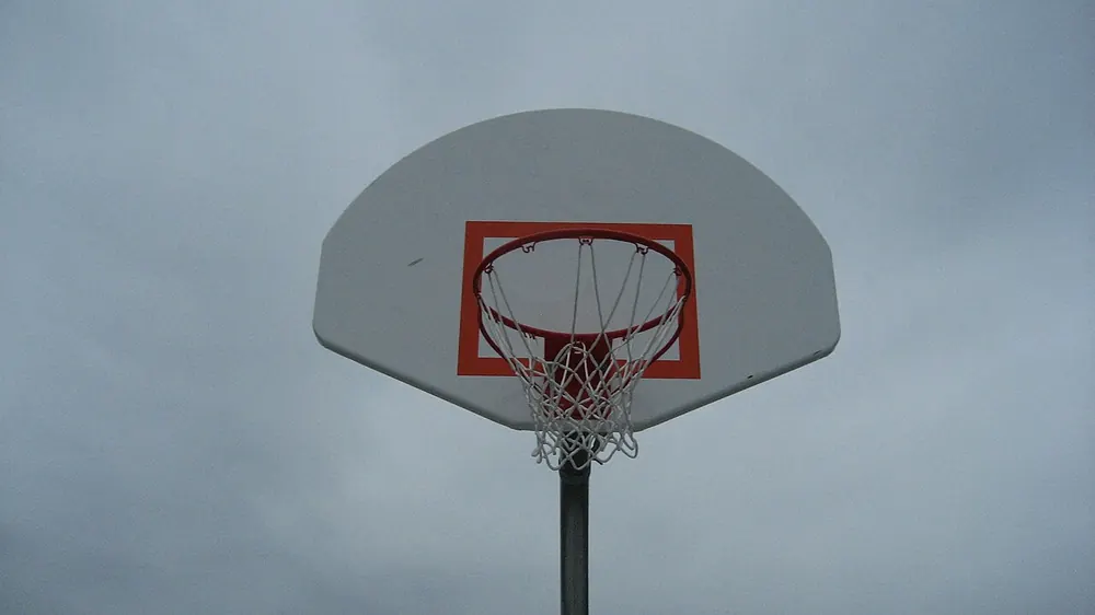 Basketball hoop and backboard against a grey sky, representing reading pba game lines - pba odds today governors cup