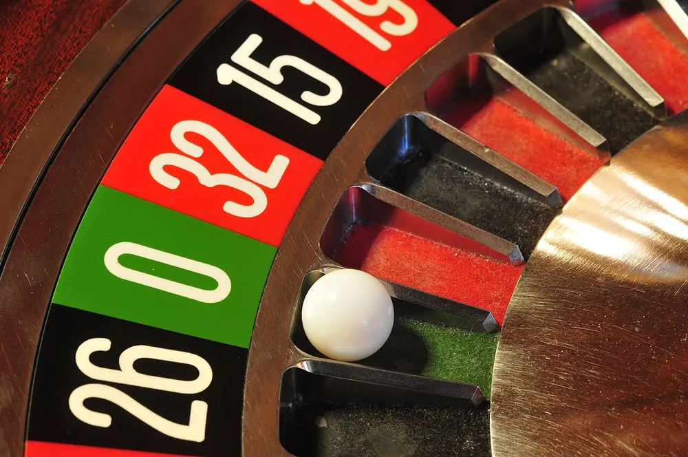 roulette strategy low risk - Close-up of a roulette wheel with the ball in the green zero pocket