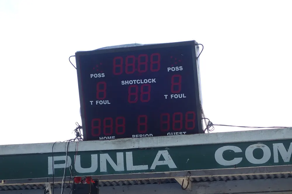 Basketball scoreboard and shot clock above a philippine court - uaap basketball betting