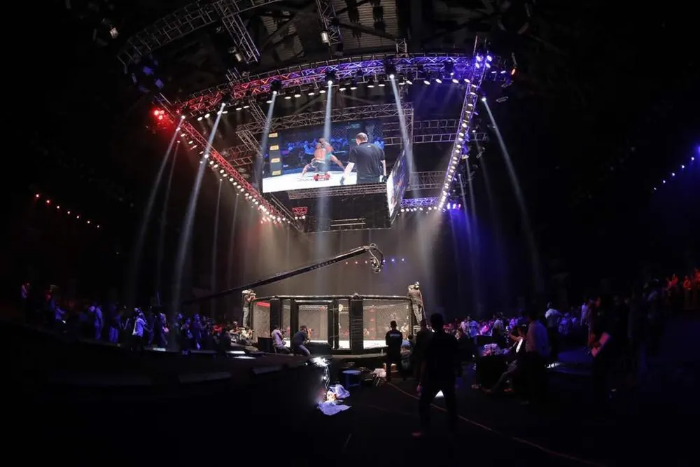 ufc filipino fighter odds - An MMA cage under arena lights in a darkened hall
