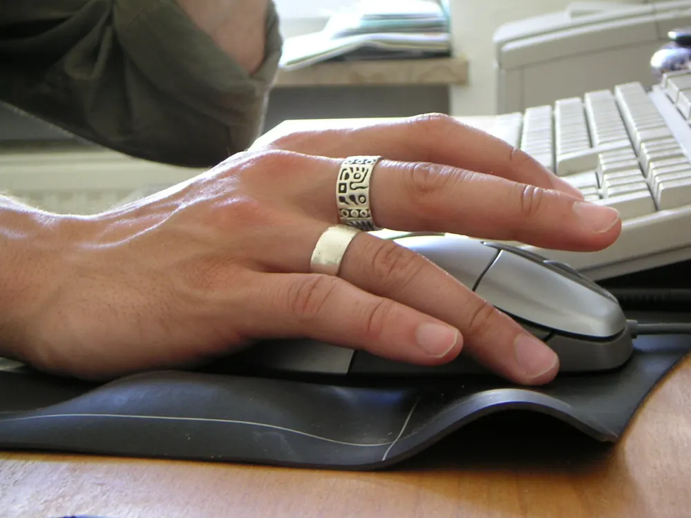 valorant betting site philippines - Hand on a computer mouse at a desk, representing PC esports such as Valorant